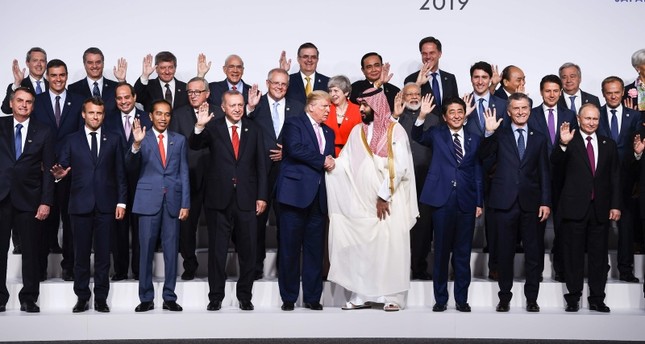 Trump shakes hands with Saudi crown prince in G20 family photo while others wave